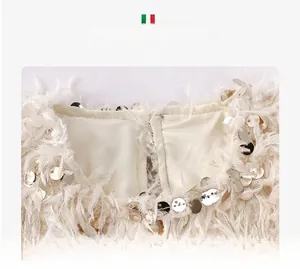 Détail de l'encolure en plumes blanches avec paillettes argentées pour filles