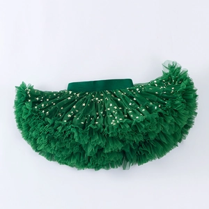 Close-up of girls green layered tutu skirt with golden star patterns and elastic waist