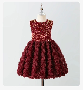 Detalle de vestido granate sin mangas con lentejuelas brillantes y falda de rosas