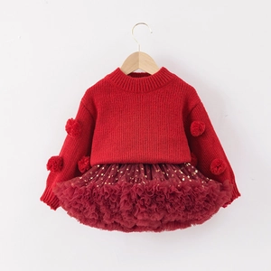 Detail of red cable knit sweater with pom-poms and gold star tulle tutu skirt set