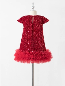 Dettaglio dell'abito da festa rosso per bambina con gonna in tulle e corpino glitterato