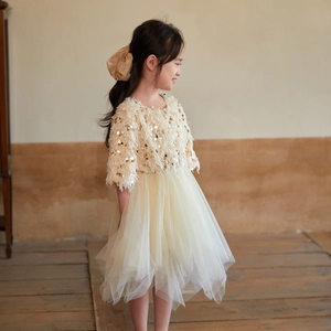 Détail d'une robe de princesse crème à paillettes avec jupe en tulle moelleuse à plusieurs niveaux