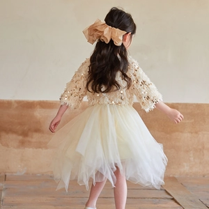 Détail du bandeau à nœud doré et du corsage à paillettes de la robe de princesse pour fille
