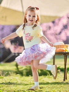 Détail d'une jupe tutu en tulle violette pour fille avec un t-shirt jaune à motif