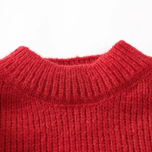 Close-up of red Christmas knit sweater featuring thick ribbed crew neck detail
