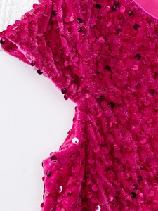 Gros plan de paillettes rose rouge sur tissu en velours doux pour robe de fille