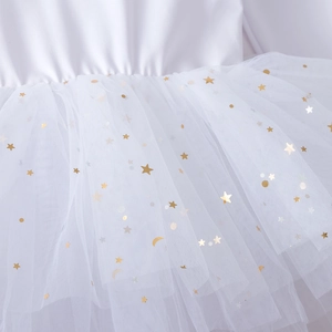 Detail of white cotton tutu skirt with gold stars and moon foil print texture