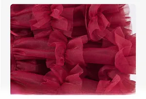 Detail of multi-layered burgundy tulle fabric showing the soft pleated texture and mesh