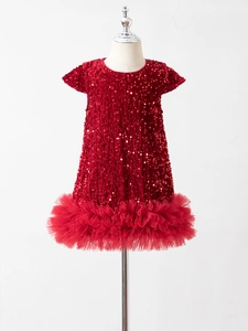 Dettaglio del corpino con paillettes rosse e gonna in tulle su abito da bimba