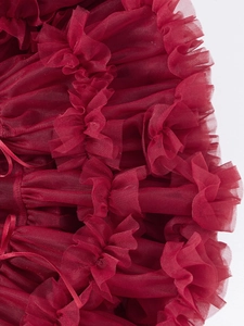 Detailed macro view of burgundy multi-layered tutu tulle fabric and satin ribbon bow