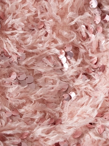 Gros plan sur le tissu à plumes roses avec paillettes métalliques d'une robe de princesse