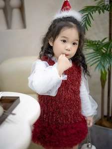 Detalle de vestido de princesa en terciopelo rojo con falda de tul y mangas de gasa blanca