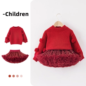 Detail of red Christmas knit sweater with pom-poms and sequined tulle tutu skirt