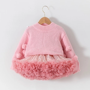 Detail of pink knitted sweater with 3D pom-poms and matching layered tulle tutu skirt