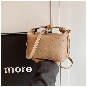 Détail du sac polochon beige avec motif rich rabbit embossé et boucle dorée