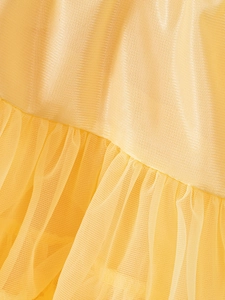 Close-up of yellow girl's tutu skirt featuring layered tulle and glossy satin fabric