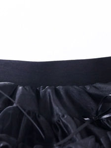 Detail of multi-layered black tutu skirt featuring elastic waistband and pleated fabric