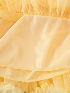 Detailed macro view of light yellow layered mesh tutu skirt with satin lining and fine stitching