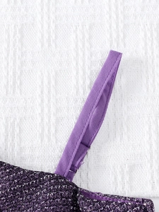 Détail du tissu à paillettes violettes et bretelle cousue d'une robe de fête enfant