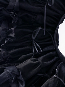 Detail showing the intricate pleated black tulle and delicate ribbon bow of the tutu skirt