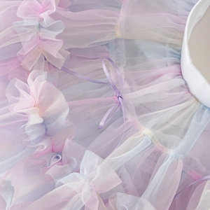 Close-up of pastel gradient layered tulle skirt with purple ribbon bow detail