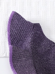 Gros plan sur le tissu pailleté violet et le passepoil en satin de la robe enfant