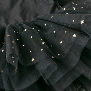 Detail of black mesh fabric featuring golden foil star and moon patterns for tutu dresses