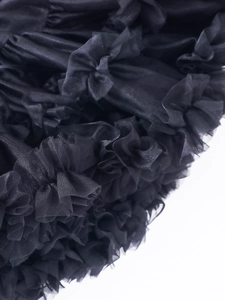 Close-up detail of tiered black mesh tutu skirt with layered ruffles and high volume texture