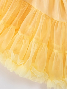 Close-up of bright yellow multi-layer polyester mesh tutu skirt with ruffled texture