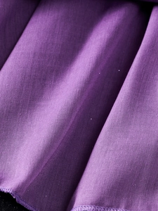 Détail macro du tissu plissé violet montrant la texture fine pour robe d'enfant