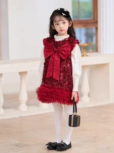 Detalle de vestido festivo rojo con lentejuelas y lazo para niña con top blanco cálido