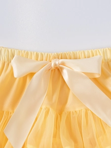 Bright yellow layered tulle tutu skirt for girls featuring a decorative satin waist bow
