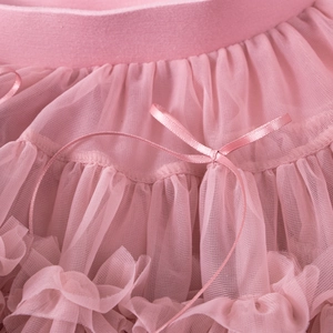 Detailed close-up of pink multi-layered mesh tutu skirt with soft satin bow accent