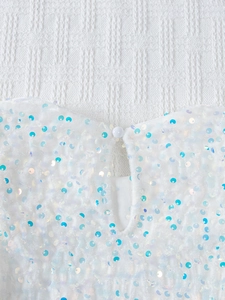 Détail de l'encolure arrière avec un bouton blanc sur une robe à paillettes fille