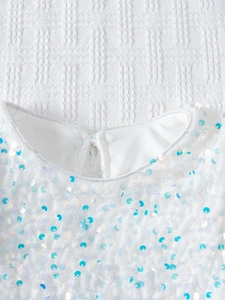 Détails de sequins irisés sur robe en tulle blanc avec finitions de couture soignées