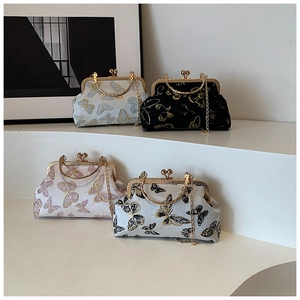 Detail view of retro butterfly embroidery on silk shell bags in white, pink and blue