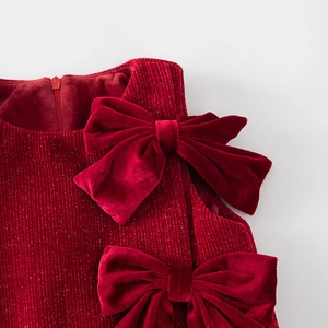 Detalle de lazos de terciopelo rojo y tela de pana brillante para vestido niña