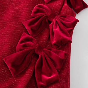 Detalle de vestido rojo para niña con corduroy brillante y lazos de terciopelo suave