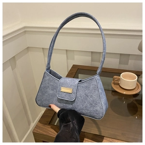 Detail of light blue faux suede shoulder bag with elegant golden rectangular buckle