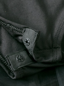 Detailed macro view of dual snap buttons on black long sleeve ballet tutu dress for girls