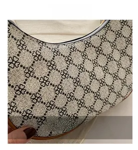 Gros plan du sac hobo en toile vintage avec imprimé trèfle et détails en cuir marron