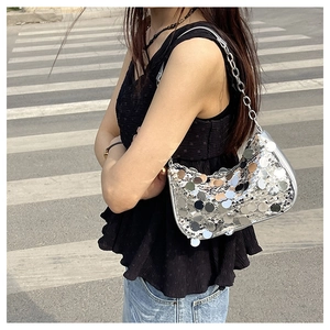 Gros plan d'un sac à bandoulière à paillettes argentées avec chaîne en métal sur rue
