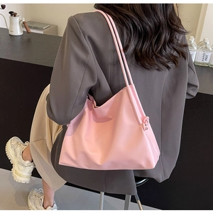 Detail of pink nylon tote bag with shoulder strap and side knot showing material texture
