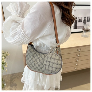 Détail du sac selle vintage à monogramme avec pochette ronde et bandoulière brune