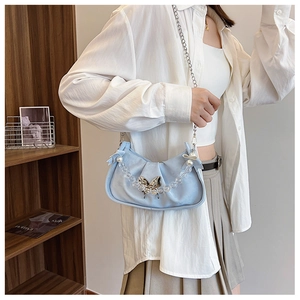 Detail of light blue pleated handbag with silver butterfly clasp and pearl chain handle