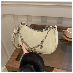 Détail du sac sous le bras croissant vert clair avec cuir synthétique plissé et chaîne