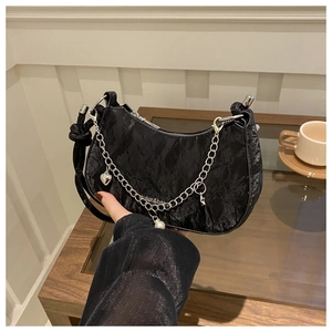 Détail du sac selle plissé noir avec chaîne argentée et breloques cœur et étoile