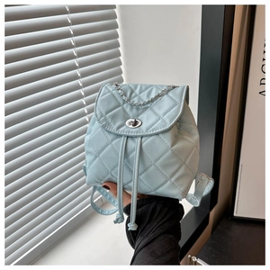 Detail shot of light blue mini bucket backpack with quilted pattern and chain handle