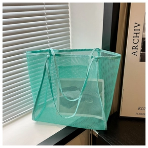 Detail of mint green mesh tote bag with breathable texture and matching long strap