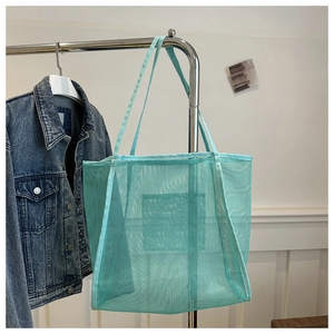 Detail shot of mint green mesh tote bag showing breathable woven texture and long straps